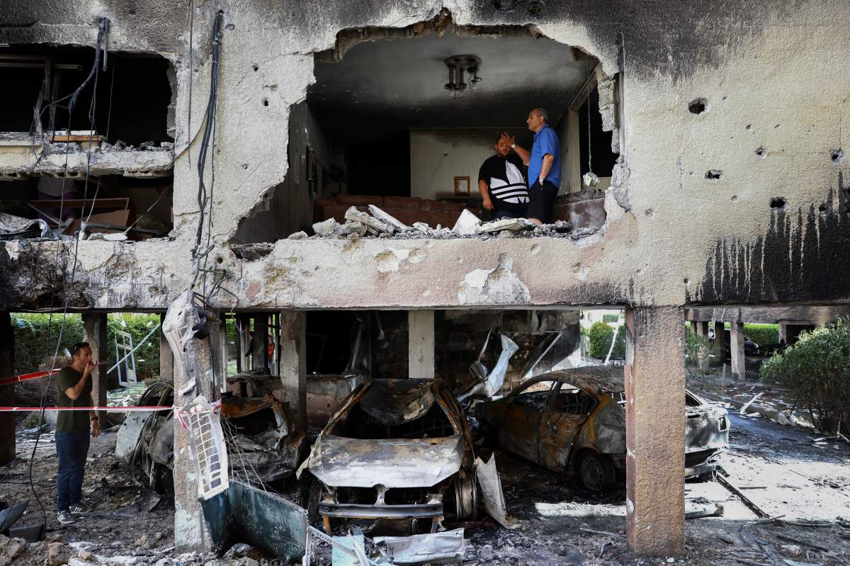 Members of Sror family inspect the damage of their apartment after it was hit by a rocket fired from the Gaza Strip over night in Petah Tikva, central Israel, Thursday, May 13, 2021.