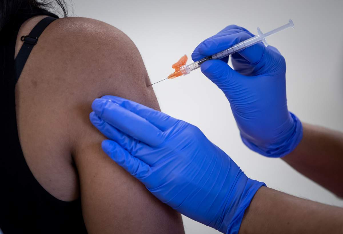 A woman receives her first dose of the Pfizer COVID-19 vaccine at an immunization clinic at the Gurdwara Dukh Nivaran Sahib, in Surrey, B.C., on Friday, May 14, 2021. 