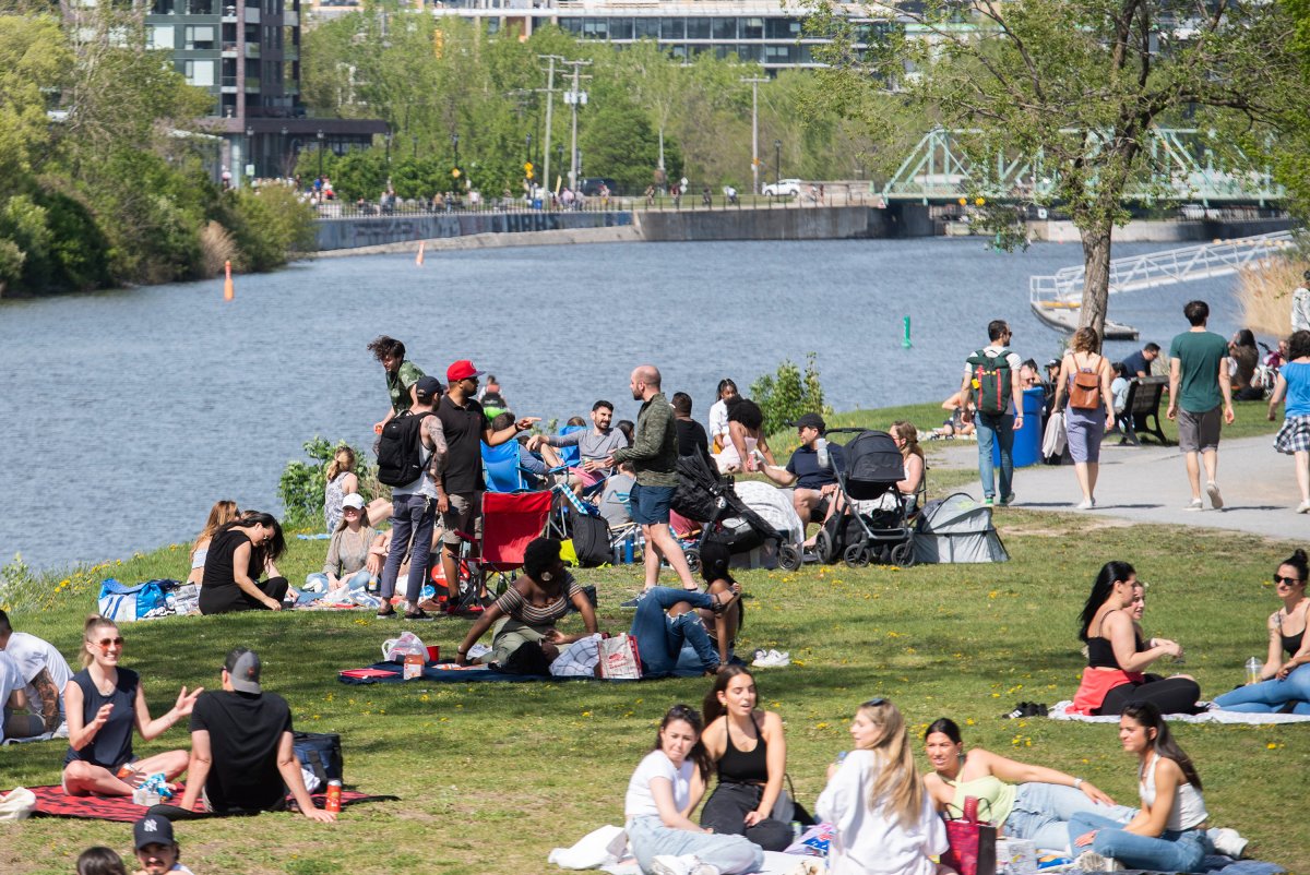 People gather next to the Lachine Canal on a warm spring day in Montreal, Saturday, May 15, 2021, as the COVID-19 pandemic continues in Canada and around the world. 