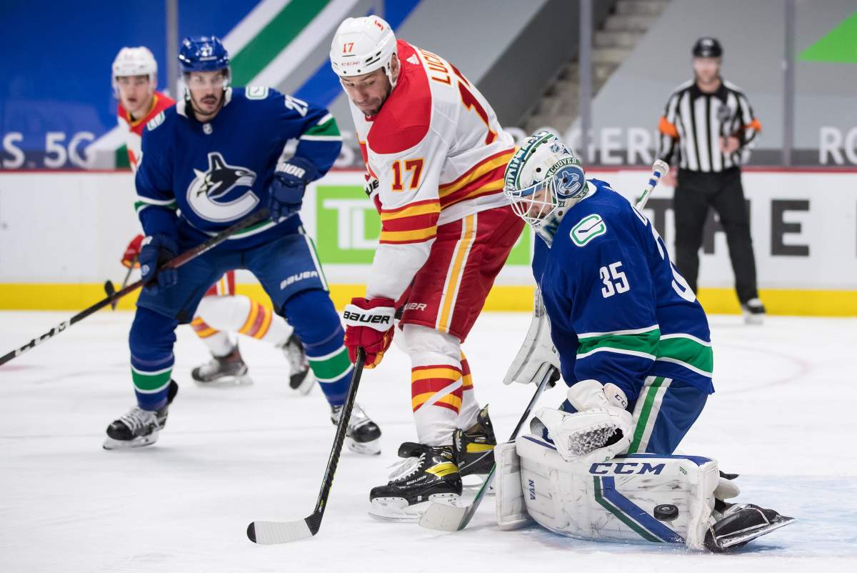 Vancouver Canucks goalie Thatcher Demko (35) makes the save as Calgary Flames’ Milan Lucic (17) watches during the third period of an NHL hockey game in Vancouver, on Tuesday, May 18, 2021.