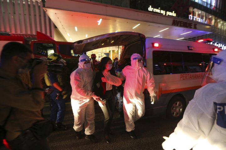 Rescue personnel help an injured passenger at KLCC station after two light rail trains collided in a tunnel, injuring more than 200 people in Kuala Lumpur, Malaysia, Monday, May 24, 2021. 