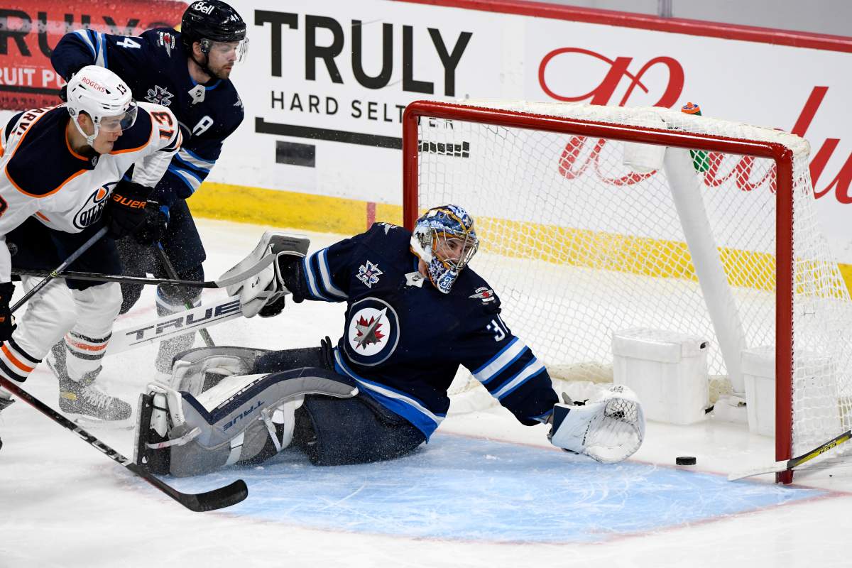 Winnipeg Jets goaltender Connor Hellebuyck (37) is scored on by Edmonton Oilers Connor McDavid, not shown, during first period NHL Stanley Cup playoff action in Winnipeg on Monday, May 24, 2021.