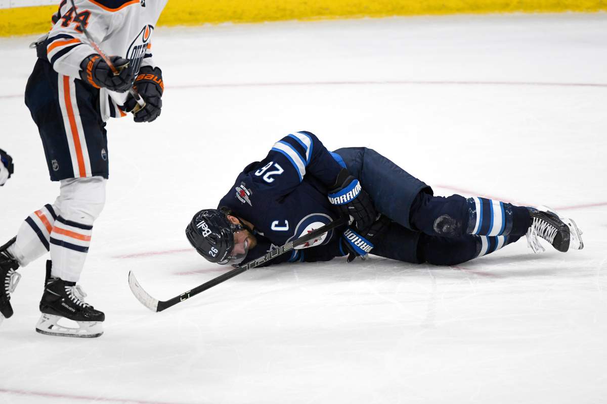 Winnipeg Jets’ Blake Wheeler (26) lies on the ice after getting hit by a shot during third period NHL Stanley Cup playoff action against the Edmonton Oilers, in Winnipeg on Monday, May 24, 2021.