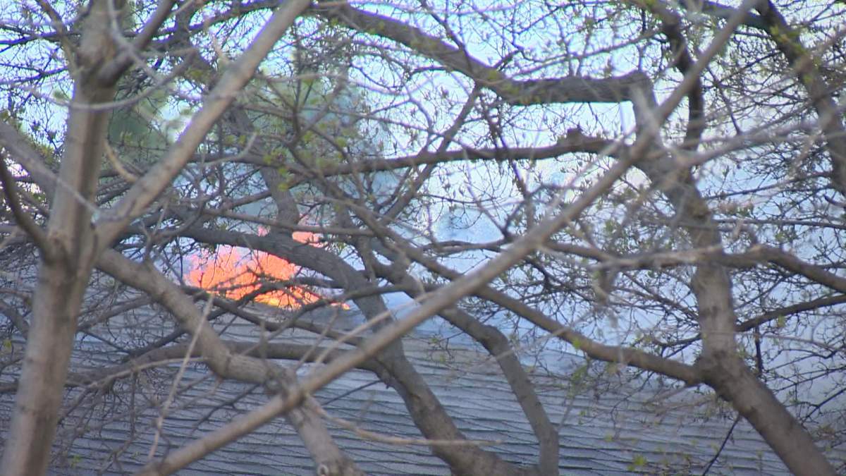 Flames could be seen flickering through holes in the roof as several Saskatoon firefighters worked to put out the blaze at the home on Capilano Drive on Thursday, May 13, 2021.