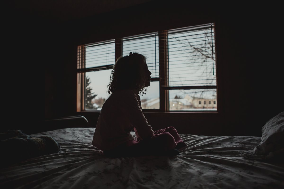 Silhouette of Little girl sitting on bed mental health children