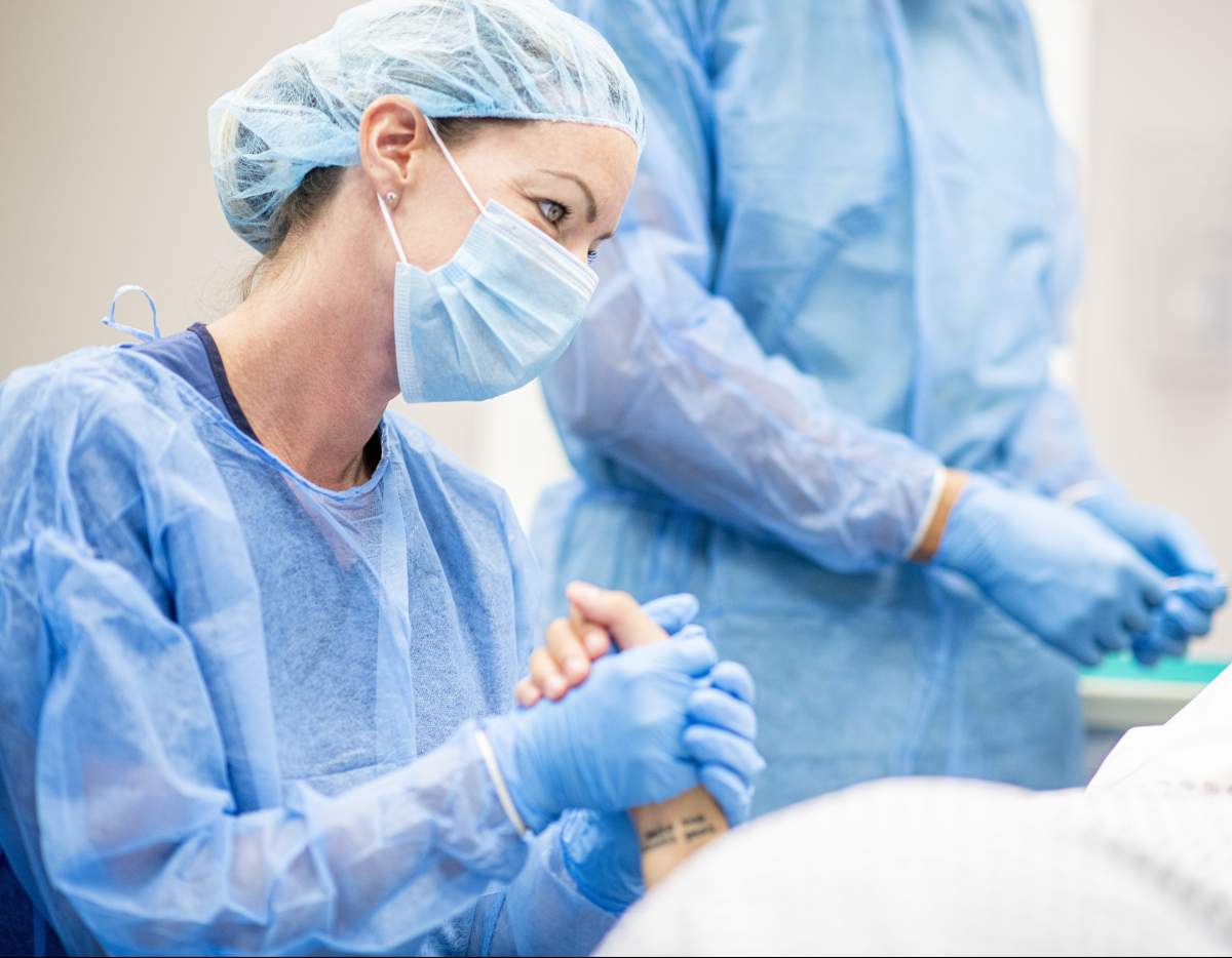 Team of doctors and nurses wear masks and gloves and prepare for surgery.