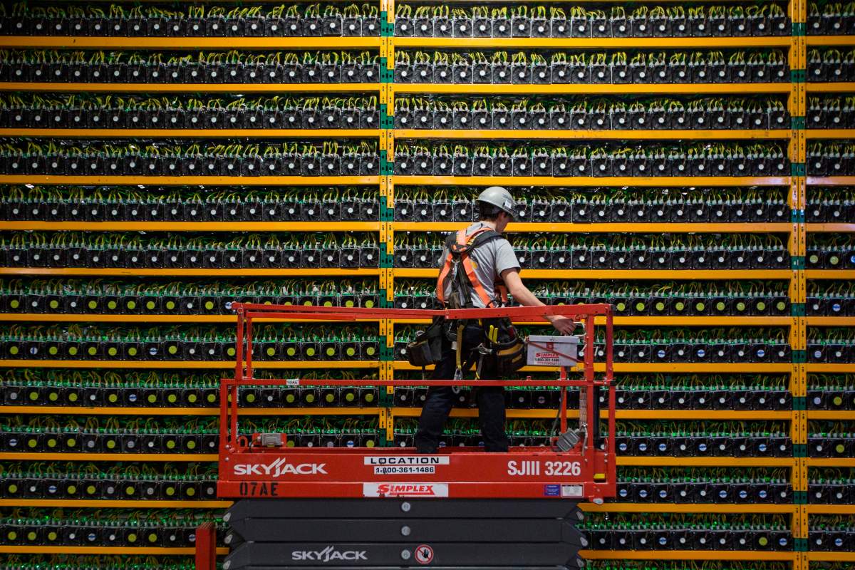 A technician inspects the backside of bitcoin mining at Bitfarms in Saint Hyacinthe, Quebec on March 19, 2018.