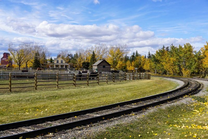 Train tracks snake around historical buildings in Calgary Heritage Park.