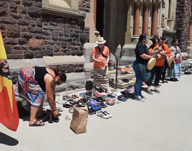 More than 150 people gathered at St. Peter’s Cathedral Basilica Sunday and laid pairs of children’s shoes on the steps as a memorial to the lives lost.