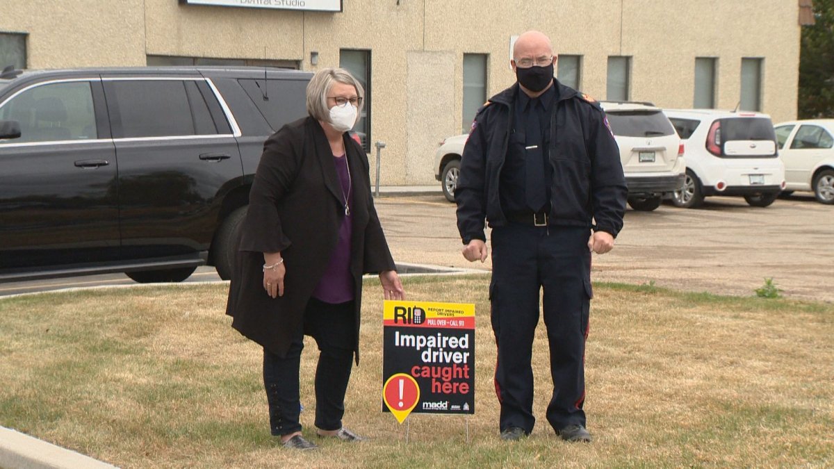 MADD Saskatoon president Bonny Stevenson and Corman Park police Sgt. Sheldon Hamm display a sign part of a campaign against impaired driving in the rural municipality.