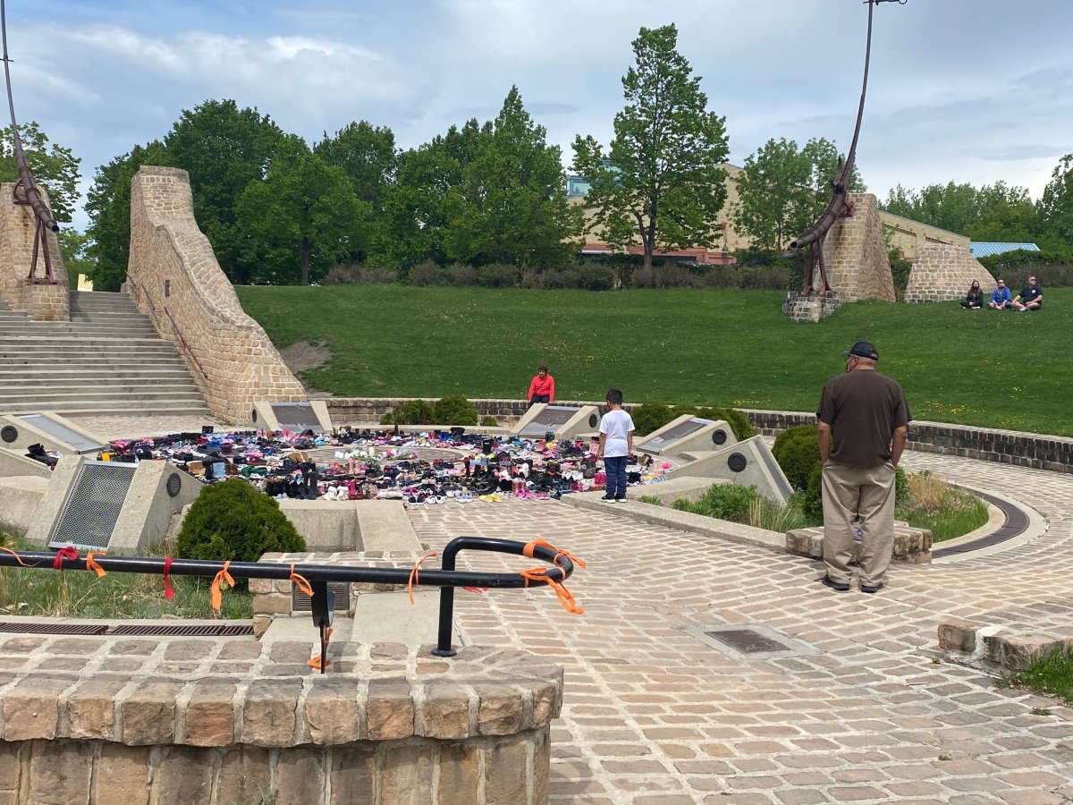 People gather at the Oodena Circle at The Forks in Winnipeg, where more than 300 pairs of shoes were collected and placed to remember those who died in a Kamloops Residential School.