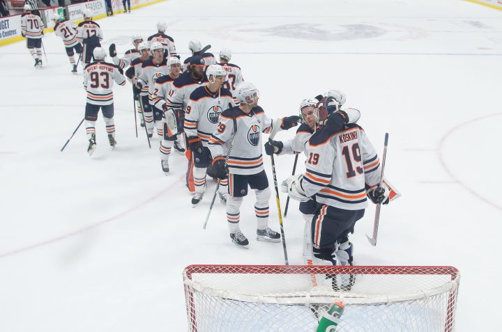 Edmonton Oilers goalie Mikko Koskinen (19), of Finland, and Connor McDavid (97) celebrate after Edmonton defeated the Vancouver Canucks 5-3 during an NHL hockey game in Vancouver, B.C., Monday, May 3, 2021.