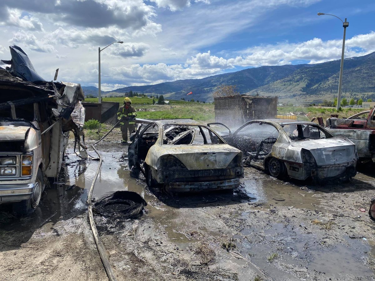 A firefighter looks at the smoking, charred remains of several vehicles that were torched in Oliver, B.C., on Friday. The vehicles had been used by the fire department for training.