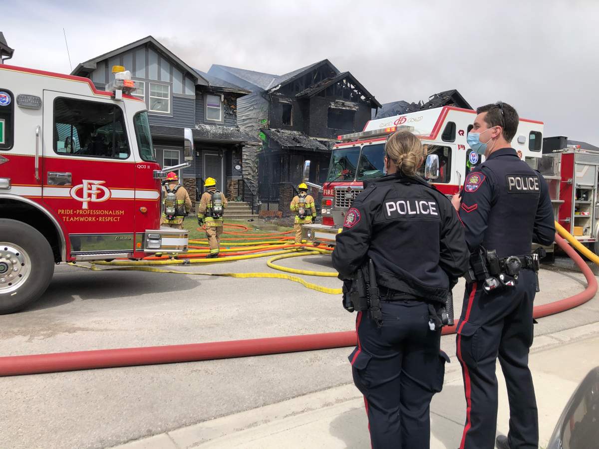 Calgary police on the scene of a fire that forced people out of three homes in Skyview Ranch on Tuesday.