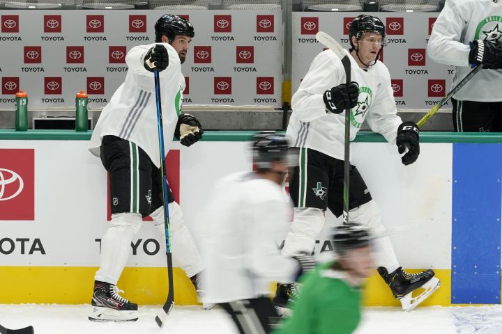 The Dallas Stars’ Jamie Benn, rear left, and Denis Gurianov, rear right, look on as teammates run through drills during NHL hockey practice in Dallas, Wednesday, Jan. 20, 2021.