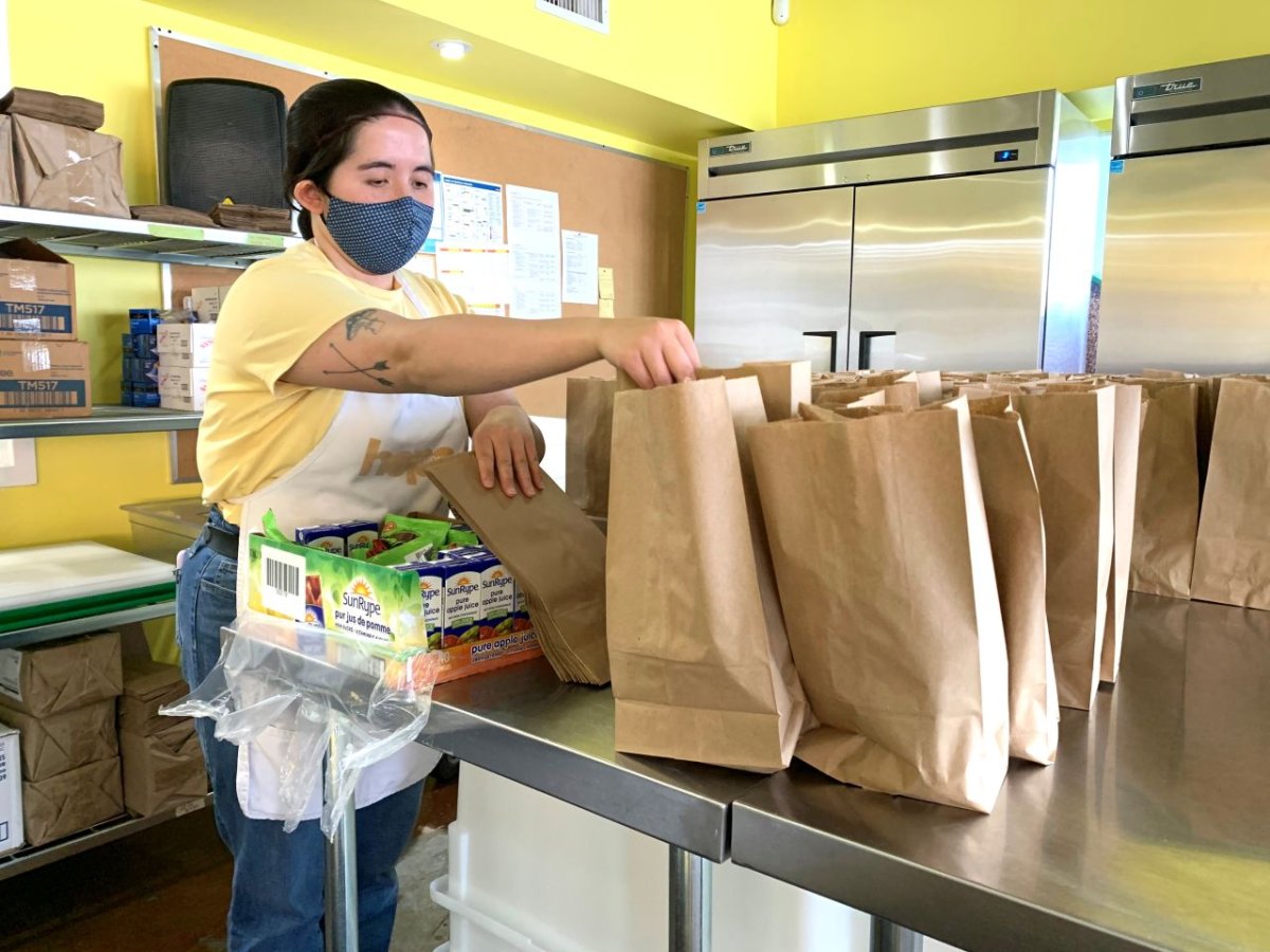 A volunteer packs free lunches at the Hope Mission's TeglerYouth Centre, Wednesday, May 12, 2021. 