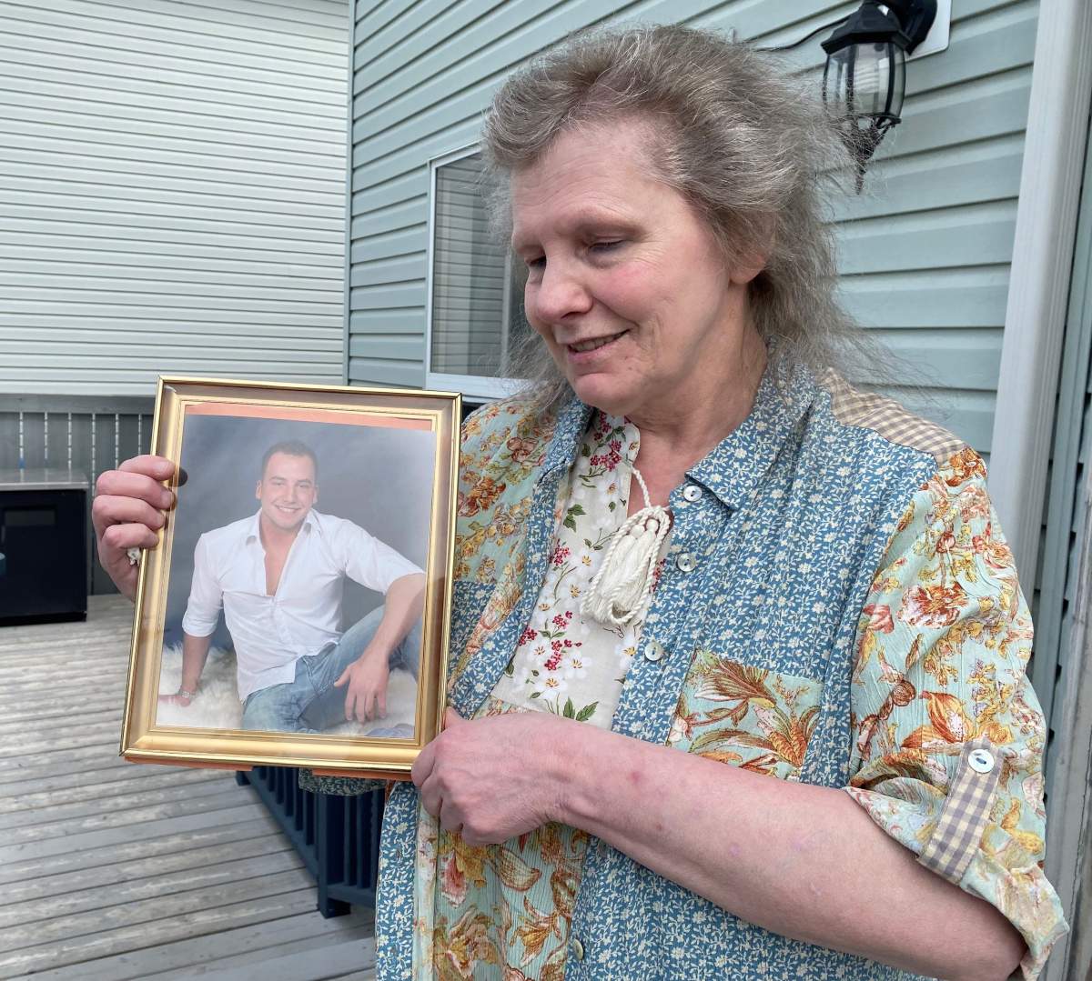 Maryann Reinke holds a photograph of her son, Gavin Zima, on May 17 2021.