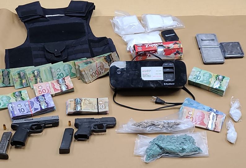 Police say officers seized nearly $200,000 in suspected drugs as well as two loaded guns and about $50,000 in cash.
