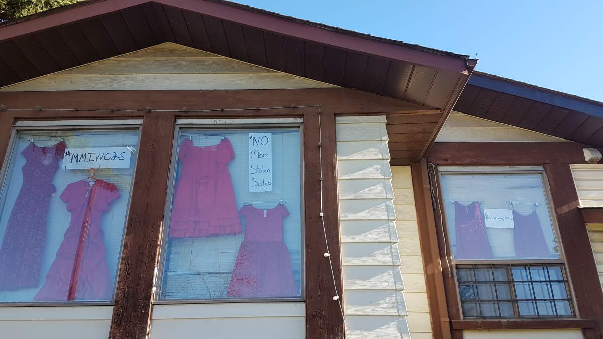 Red dresses hang in the windows of a Calgary home.