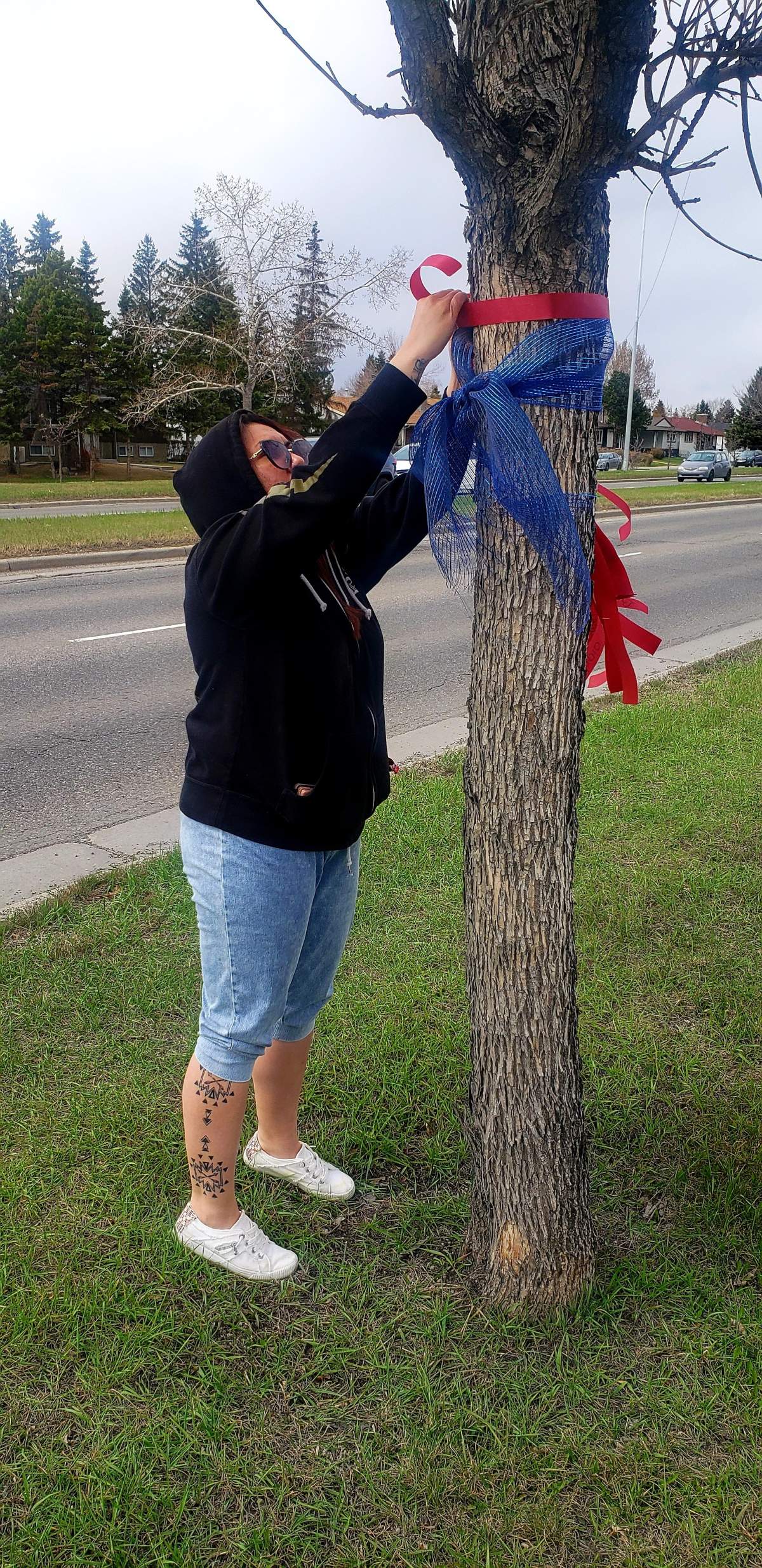 Red ribbons being hung on trees throughout Calgary.