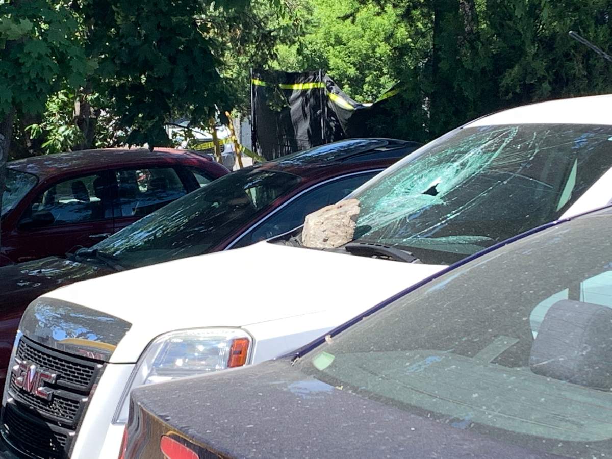 One of the vehicles at the house has a smashed windshield.