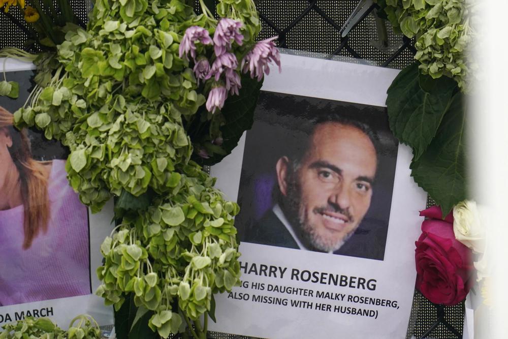 FILE – In this June 29, 2021, file photo, an image of Harry Rosenberg, missing since an oceanfront condo building collapsed in Surfside, Fla., hangs on a fence as part of a makeshift memorial.