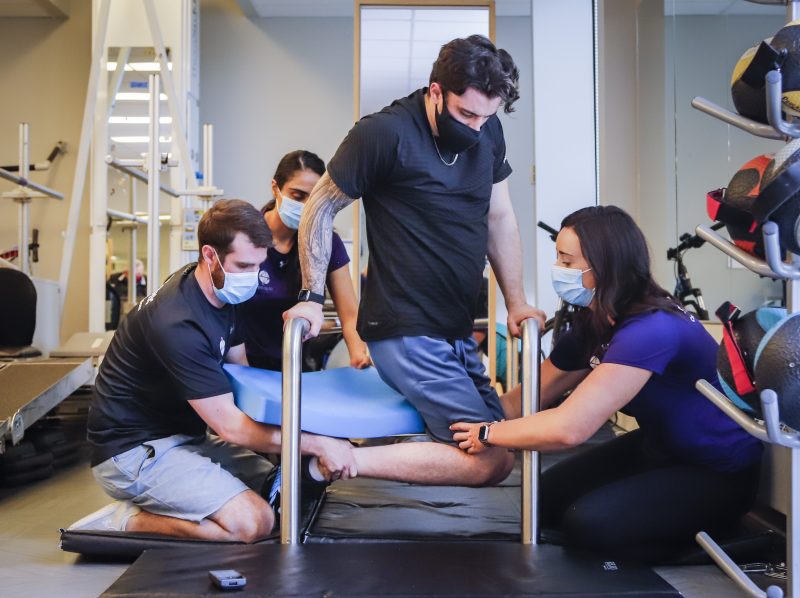 Humboldt Broncos bus crash survivor Ryan Straschnitzki, centre, is helped to turn his body by Eric Daigle, left, and Jill Mack while he attends a physiotherapy session in Calgary, Alta., Thursday, June 24, 2021.