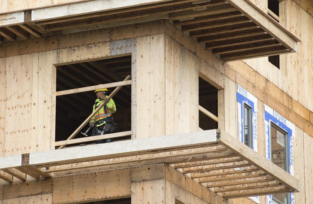 A worker handles lumber on a construction project in Vancouver, Tuesday, Apr. 23, 2019.