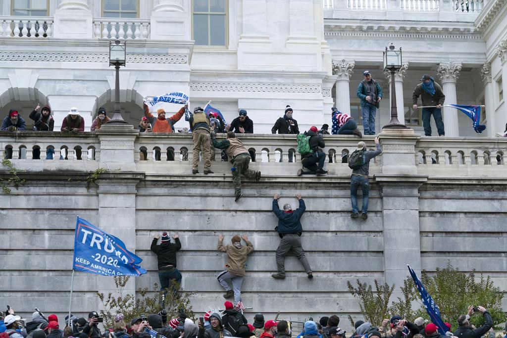 FILE - In this Jan. 6, 2021, file photo, supporters of President Donald Trump climb the west wall of the the U.S. Capitol in Washington, D.C.