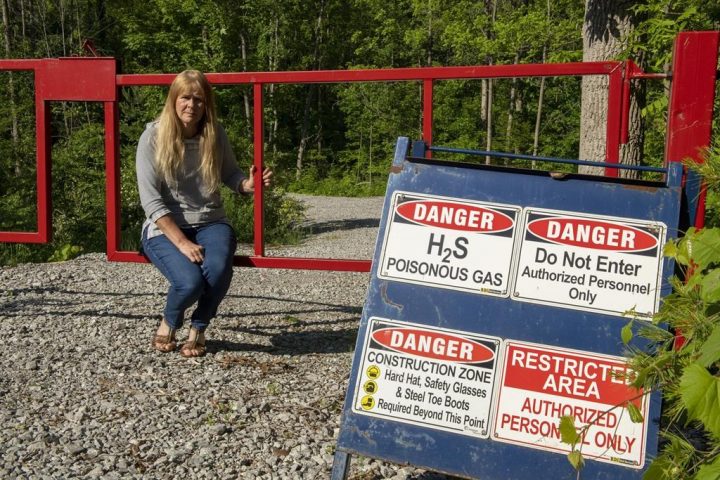 Paula Jongerden sits by a sign next to her property in Norfolk County on Thursday, June 10, 2021.