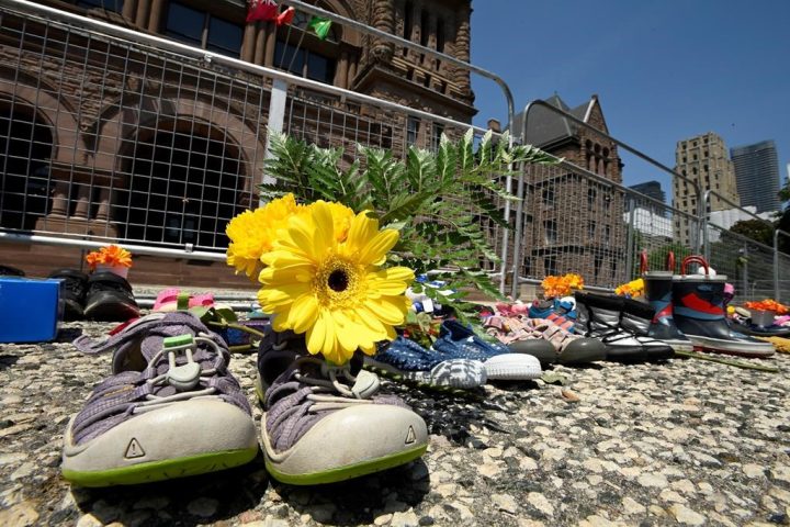 Children's shoes and flowers are shown after being placed outside the Ontario legislature in Toronto on Monday, May 31, 2021. 