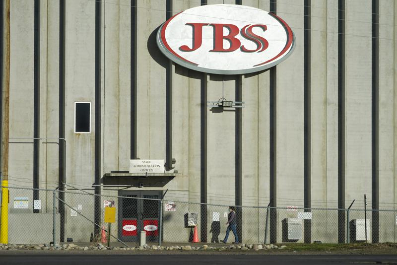 FILE - In this Oct. 12, 2020 file photo, a worker heads into the JBS meatpacking plant in Greeley, Colo. A weekend ransomware attack on the world’s largest meat company is disrupting production around the world just weeks after a similar incident shut down a U.S. oil pipeline. The White House confirms that Brazil-based meat processor JBS SA notified the U.S. government Sunday, May 30, 2021, of a ransom demand from a criminal organization likely based in Russia. 