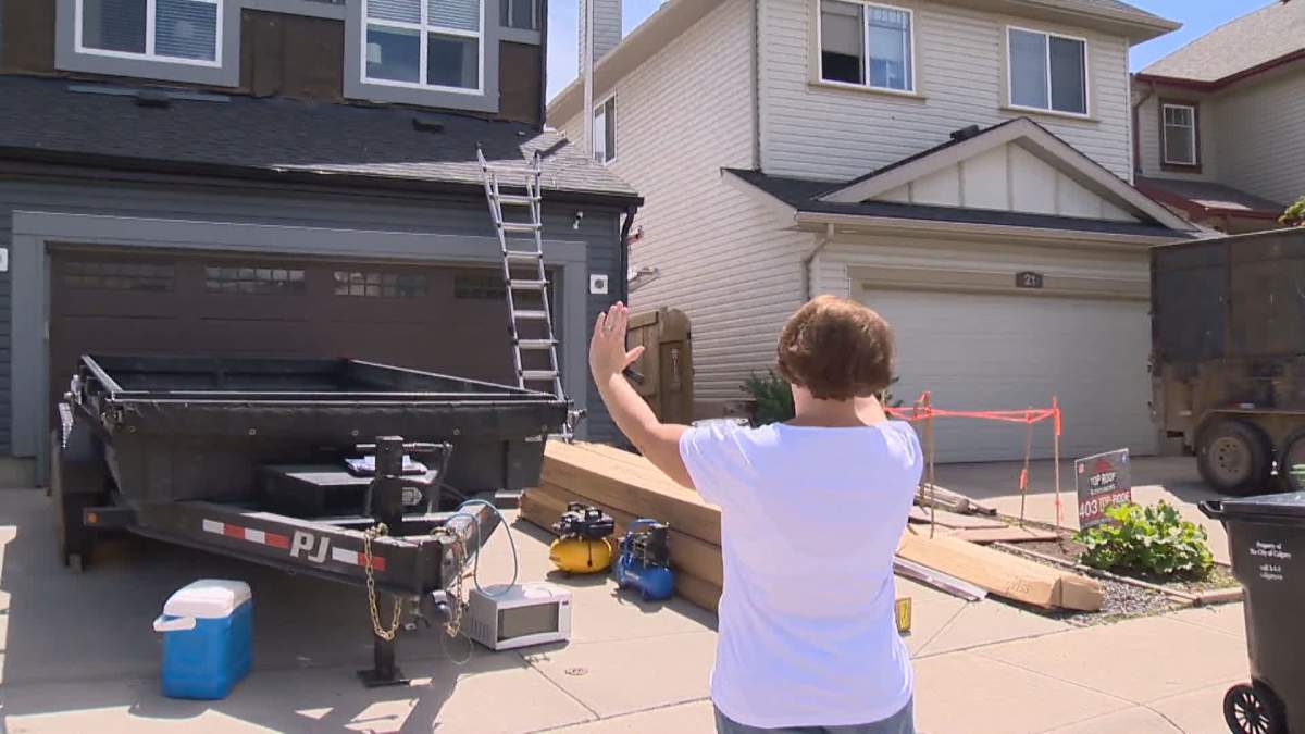 Calgary homeowner admires the work being done on her storm ravaged home