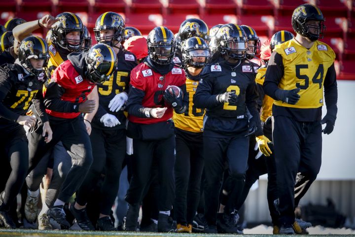 Hamilton Tiger-Cats quarterback Dane Evans, centre, runs onto the field with teammates during practice for Sunday's CFL Grey Cup football game in Calgary, Friday, Nov. 22, 2019.