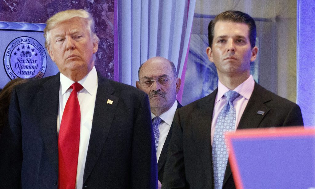 FILE - In this Jan. 11, 2017 file photo, Allen Weisselberg, center, is seen between President-elect Donald Trump, left, and Donald Trump Jr., at a news conference in the lobby of Trump Tower in New York.