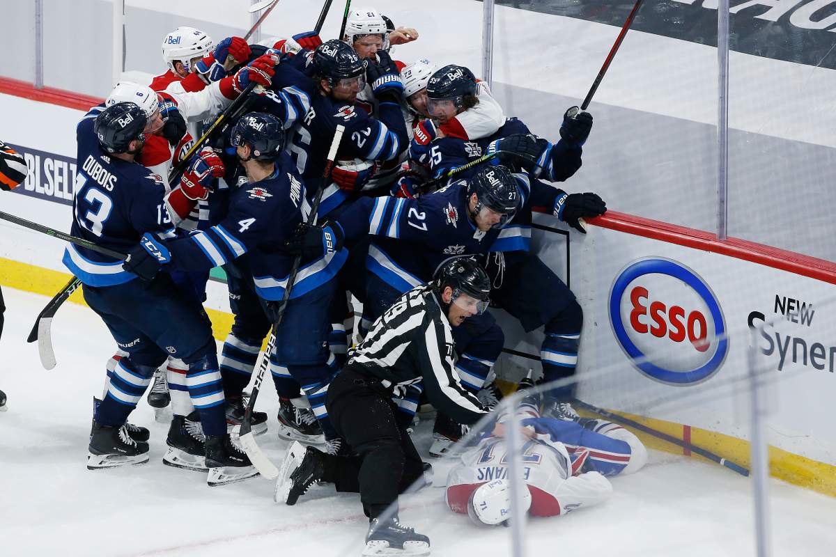 Montreal Canadiens’ Jake Evans (71) is protected as he lies motionless on the ice after getting hit by Winnipeg Jets’ Mark Scheifele (55) during third period NHL Stanley Cup hockey action in Winnipeg, Wednesday, June 2, 2021.