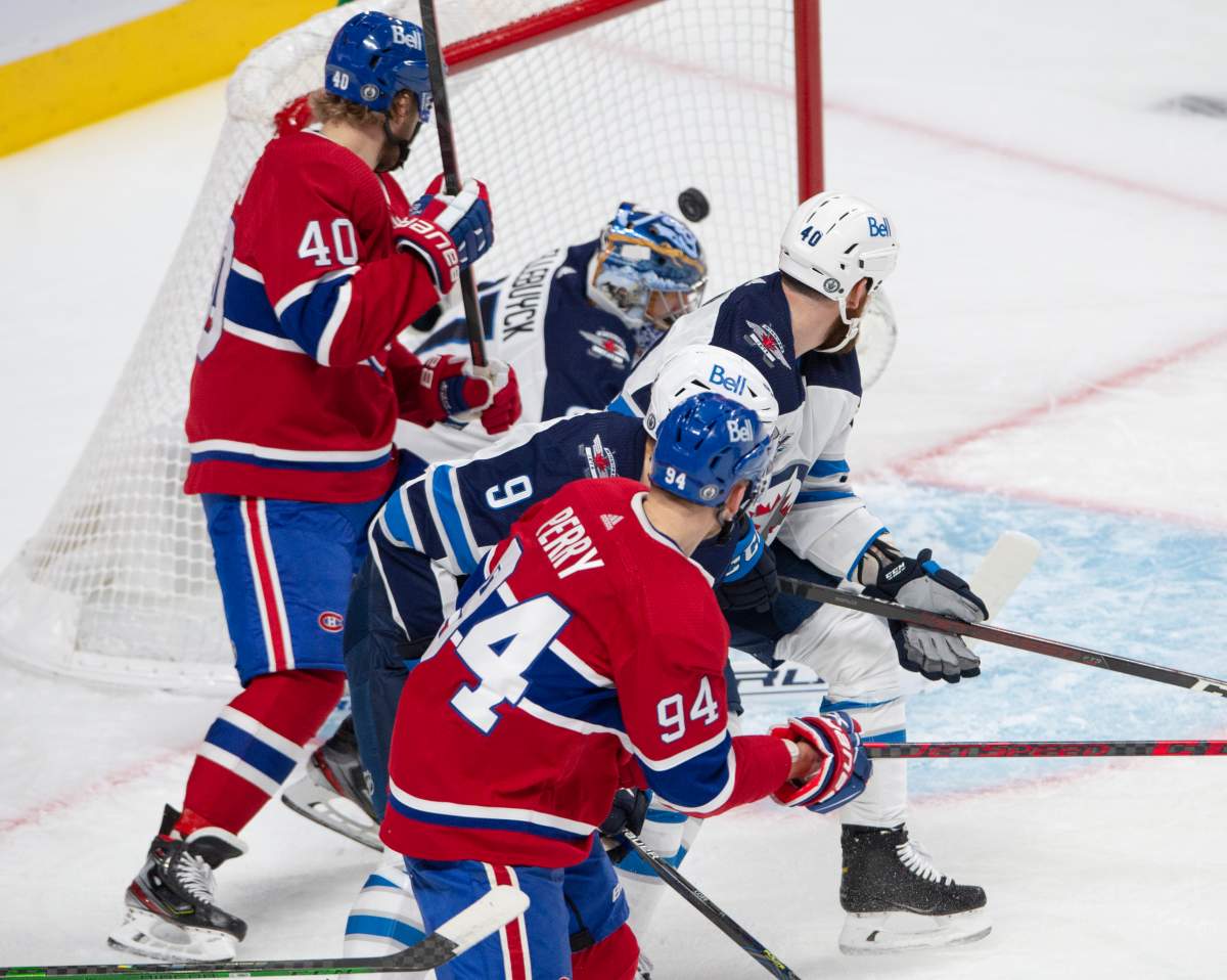 Montreal Canadiens right wing Corey Perry (94) scores the first goal on Winnipeg Jets goaltender Connor Hellebuyck (37) during first period NHL Stanley Cup playoff hockey action in Montreal, Sunday, June 6, 2021.
