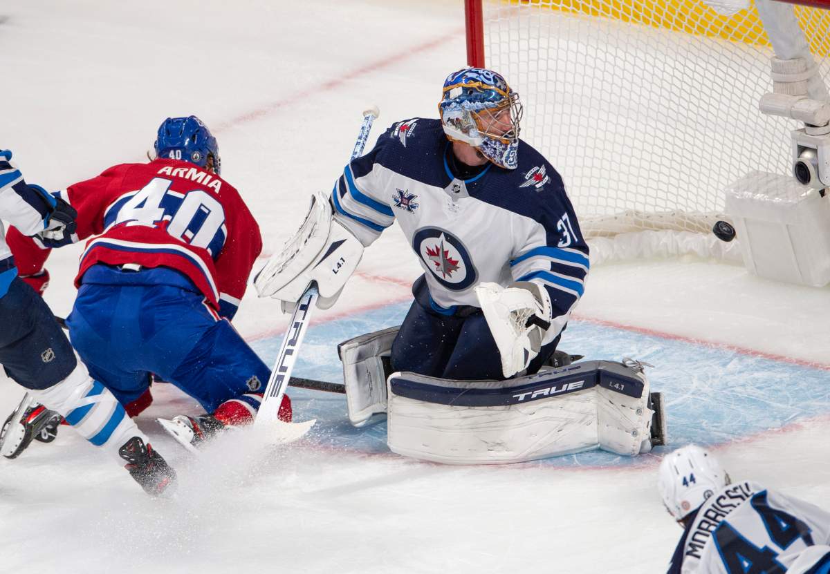 Montreal Canadiens' Joel Armia (40) scores a shorthanded goal on Winnipeg Jets goaltender Connor Hellebuyck (37) as Jets' Josh Morrissey (44) looks on during second period NHL Stanley Cup playoff hockey action in Montreal, Sunday, June 6, 2021.