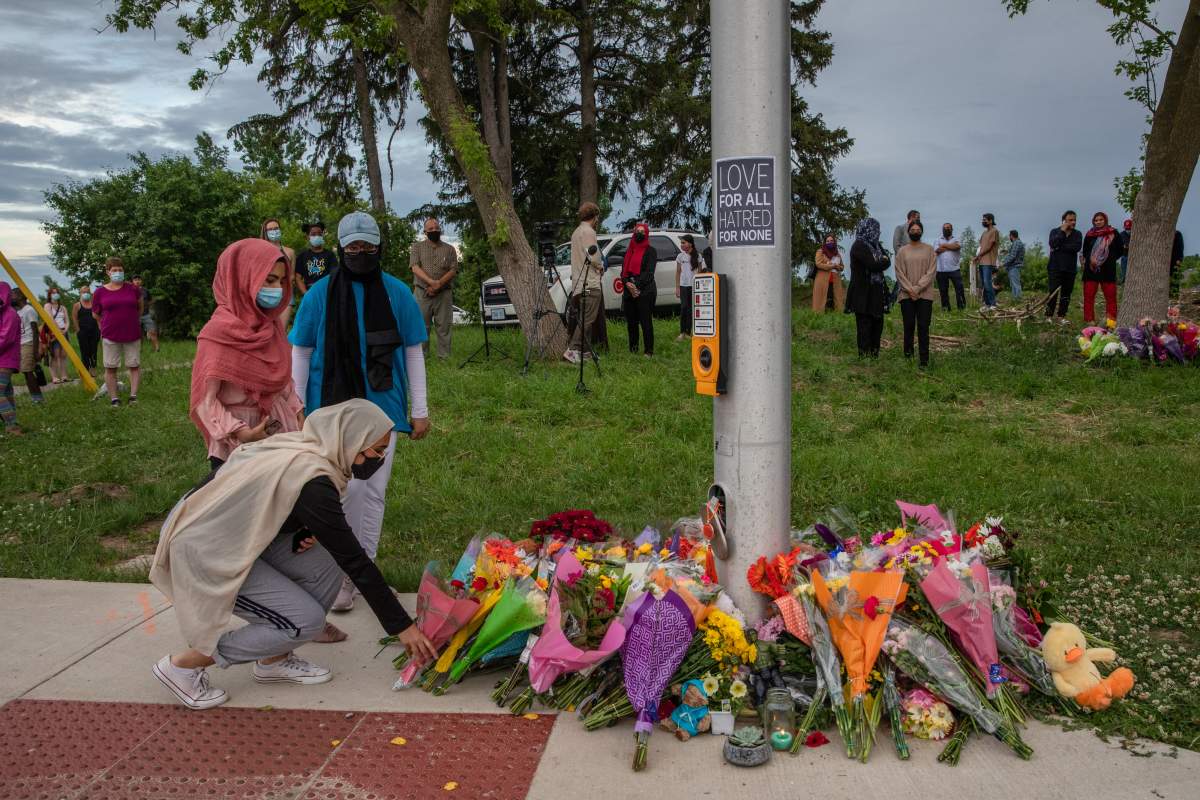 Mourners leave flowers at the site where a family of five was hit by a driver, in London, Ont., Monday, June 7, 2021. Four of the members of the family died and one is in critical condition. 