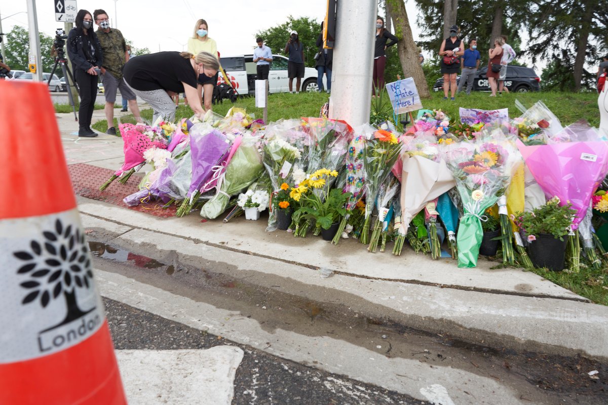 Mourners place flowers at the scene of a hate-motivated vehicle attack in London, Ont. on Tuesday, June 8, 2021, which left four members of a family dead and their nine-year-old son in hospital. THE CANADIAN PRESS/ Geoff Robins.