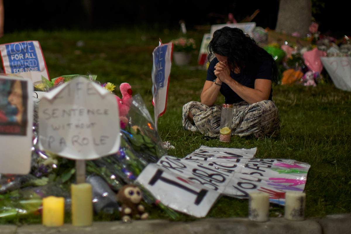 A woman sits and weeps at the scene of last year's targeted vehicle in attack in northwest London, Ont., days after the killing took place.