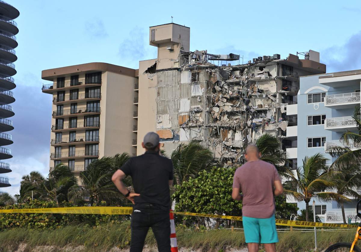 People look at the rubble at Champlain Towers South Condo in Surfside, located at 8777 Collins Avenue, a part of which collapsed in the early morning in Surfside, FL, USA, on Thursday, June 24, 2021.