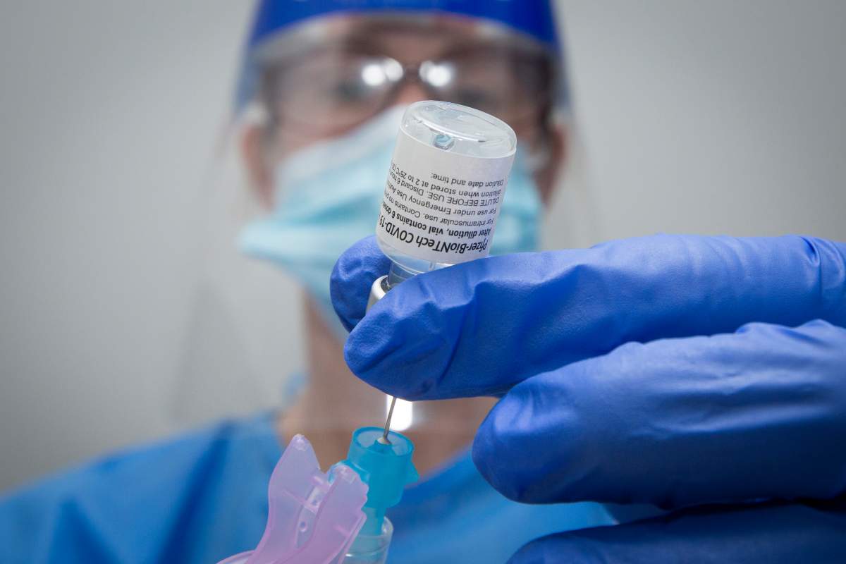 Pharmacist Suzanne Garrett draws a syringe with Pfizer-BioNTech covid-19 vaccine at a pharmacy in Amherstview, Ontario on Friday June 25, 2021. THE CANADIAN PRESS IMAGES/Lars Hagberg.