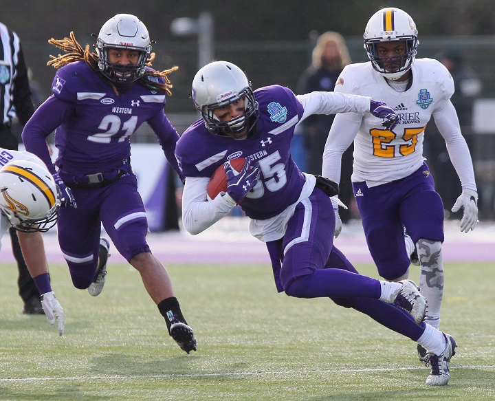 Western's Malik Besseghieur carries the ball after making a catch as team-mate Cedric Joseph (21) and Laurier's Shomari Hutchinson watch during first half action in the OUA Yates Cup, Ontario Championship football game in London, Ont., Saturday, Nov. 11, 2017.