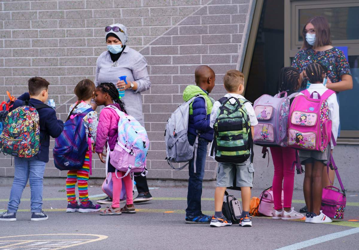 Teachers greet their students in the school yard at the Philippe-Labarre Elementary School in Montreal, on Thursday, August 27, 2020. Thousands of Quebec students return to class in the shadow of the COVID-19 pandemic. 