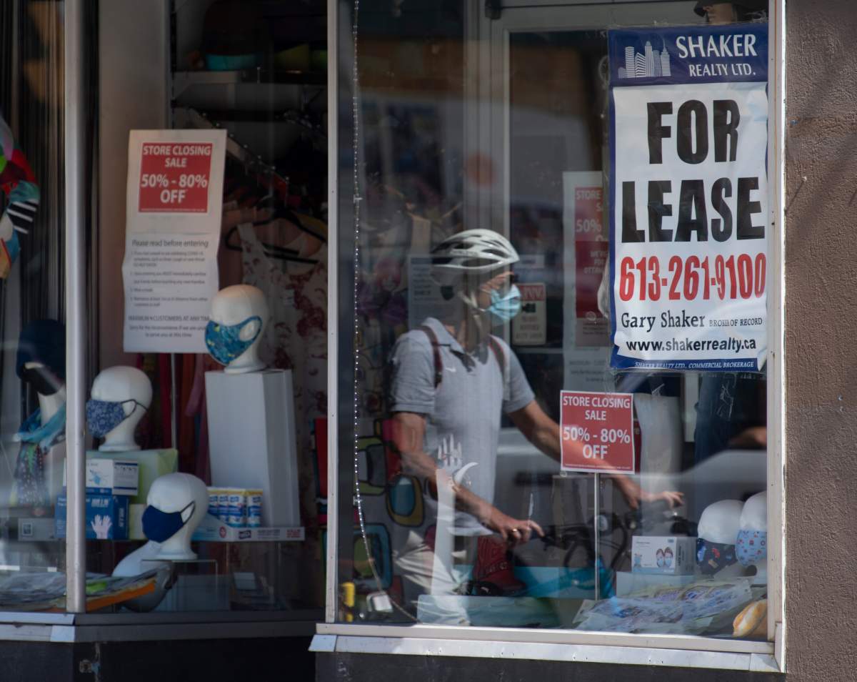 A lease sign hangs in the window as a cyclist walks past a commercial store Monday August 31, 2020 in Ottawa. 