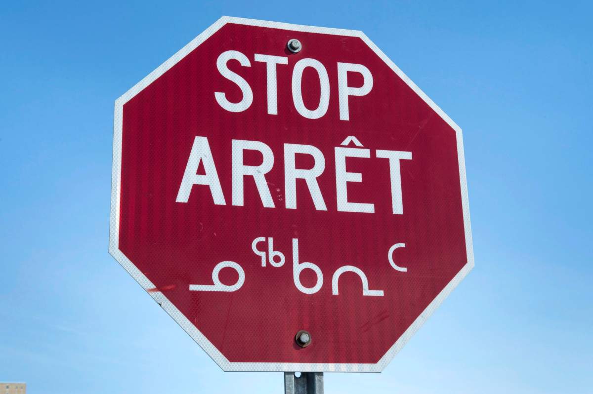 A stop sign in English, French and Inuit in Iqaluit, Nunavut.