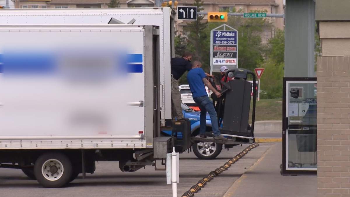 Moving crews haul gym equipment out of one GYMVMT location in Calgary
