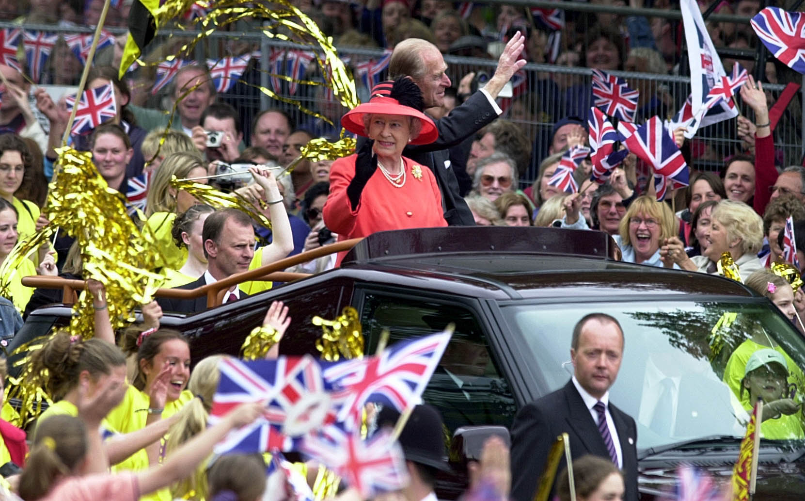 Queen Elizabeth II and Prince Phillip the Duke of Edinburgh ride along the Mall in an open-top car on their way to watch a parade in celebration of the Golden Jubilee on June 4, 2002 in London, England.
