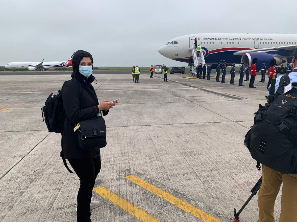 The glamourous life of tv reporting on the road in a pandemic: mask on, loaded with stuff, phone in hand, hair protected from rain.